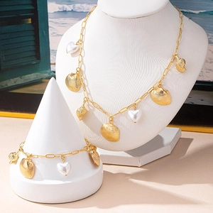 Golden ocean shell necklace and bracelet set with heart pearls on display stands