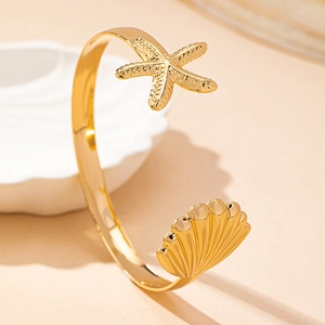 Gold open bangle featuring 3D starfish and shell charms with a polished finish