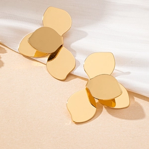 Détail de boucles d'oreilles pétales dorées avec finition miroir polie sur soie