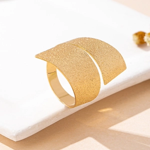 Macro detail of wide gold wrap ring with shimmering frosted surface on stone display