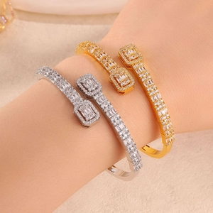 Detailed close-up of open cuff bracelets in gold and silver with shimmering pavé zircon stones
