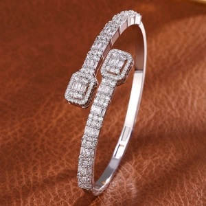 Detailed macro of silver open bangle with pave set cubic zirconia on leather