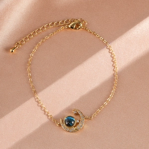 Detail of gold star and moon bracelet with blue galaxy bead and sparkling crystals