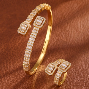 Luxurious gold open bracelet and ring set featuring rectangular cubic zirconia clusters