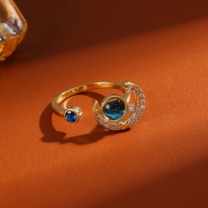 Macro shot of gold-plated celestial star and moon ring with blue starry gemstone detail