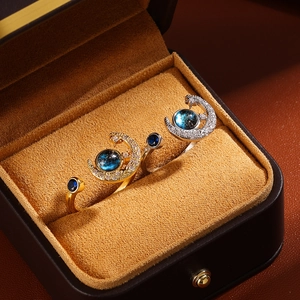 Close-up of gold and silver moon rings with blue star sand beads and crystal accents