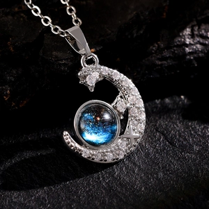 Macro detail of crescent moon pendant with blue galaxy stone and pavé cubic zirconia