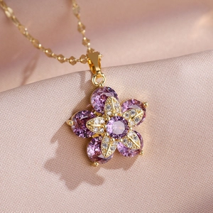 Vue macro du pendentif fleur en zircon violet rotatif sur un tissu en soie champagne