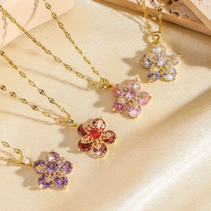 Détail de pendentifs floraux rotatifs avec zircons colorés sur chaînes dorées