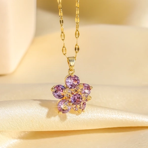Collier doré élégant avec pendentif fleur en zircon violet rotatif sur fond de soie douce