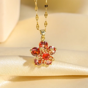 Collier avec pendentif fleur en gemme rouge à cinq pétales et centre étoilé doré