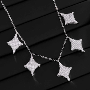 Close-up of a silver thin chain necklace with five sparkling paved four-point star charms