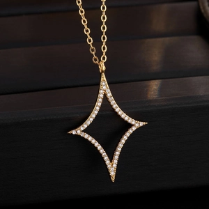Makroaufnahme von Goldstern-Anhänger mit Pavé-Diamanten auf schwarzer Samtbox