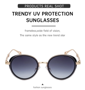 Macro detail of oval gold metal frame with gradient lenses and decorative temple design