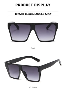 Detail view of large black square sunglasses with grey gradient lenses and glossy finish