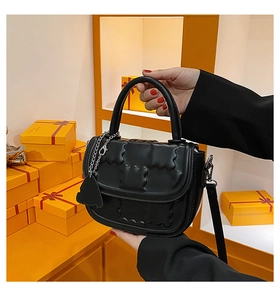 Black crossbody bag with cloud texture, silver bear pendant, and orange gift boxes