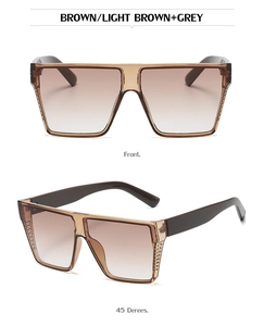 Detail of square oversized sunglasses showing vertical stripe frame texture and brown gradient lenses