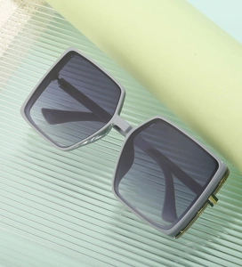 Detail of matte gray TR square sunglasses featuring golden metal hinge and dark lenses