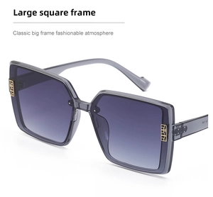 Detail view of large square gray frames with gold metal geometric temple accents
