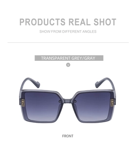 Detail of transparent grey polarized sunglasses with golden square hollow hinge decoration