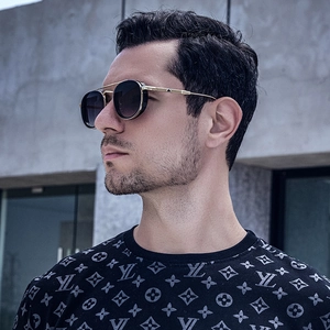 Detail view of vintage oval sunglasses with side shields and golden metal frame on model