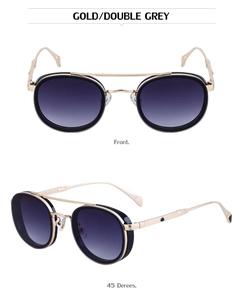 Detail view of oval metal sunglasses with gold frames and grey gradient lenses