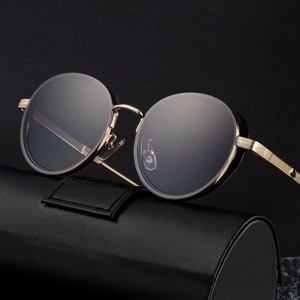 Retro oval metal sunglasses with gold frame and dark lenses on a black leather case