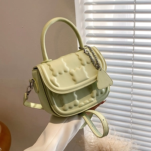 Mint green PU leather crossbody bag with embossed patterns and top handle