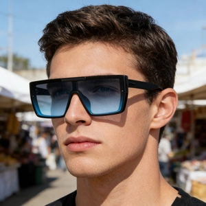 Fashionable oversized square sunglasses with blue gradient lenses on a model in sunlight