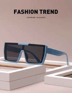 Detail of square oversized sunglasses with blue frames on white geometric display props