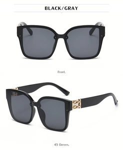 Detail of square sunglasses with gray lenses and golden metal chain link on temples