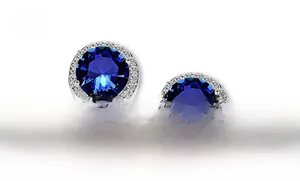 Detail of round halo earring featuring a royal blue cubic zirconia with micro-pave crystals