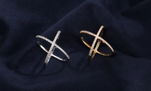 Macro detail of gold and silver crossover X-shaped rings with micro-pave crystals