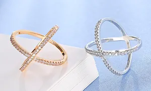 Detailed view of cross-shaped pave-set zircon rings in silver and rose gold finish