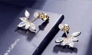 Detailed close-up of golden fan-shaped ear studs with brilliant AAA cubic zirconia stones