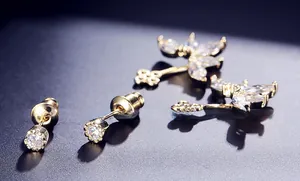 Macro shot of gold-plated stud earrings featuring AAA zircons on a dark surface
