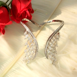 Vue détaillée du bracelet jonc ailes d'ange argenté avec zircons sur plumes blanches