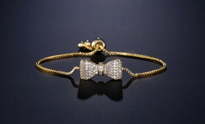 Nahaufnahme des goldenen Schleifenarmbands mit Zirkon-Pavé und verstellbarem Gleitverschluss