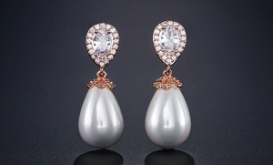 Detail of rose gold teardrop earrings with zircon pavé and white iridescent pearls