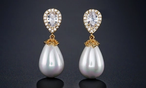 Detail of elegant gold drop earrings with pear-cut zircon stones and white teardrop pearls