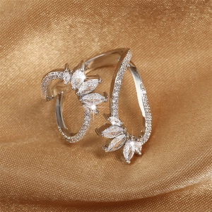 Silver open ring with marquise zircon stones in a leaf design on golden satin fabric