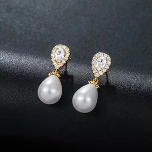 Vintage waterdrop pearl earrings with zircon inlay on a textured black background