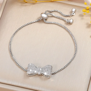 Verstellbares Schleifenarmband mit Zirkonia auf einer champagnerfarbenen Schmuckschatulle