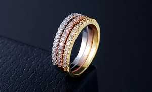 Detailed close-up of three stackable zircon rings in gold, silver, and rose gold finish
