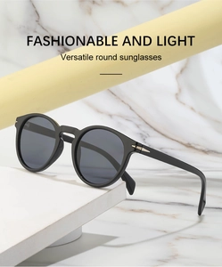 Detail of round black sunglasses featuring stylish metal arrow decor on temples