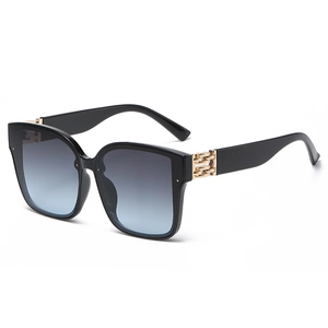 Fashionable black square oversized sunglasses with gradient lenses and gold chain temples