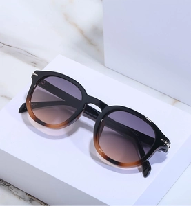 Detail view of round vintage sunglasses with gradient frames and silver arrow accents