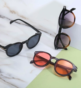 Close-up of retro round frame sunglasses in black, tortoise, and grey texture finishes