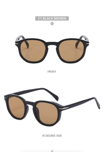 Detail of retro round sunglasses with black frames, brown lenses, and silver arrow accents