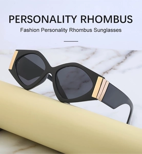Detail of black rhombus sunglasses with decorative gold metal bar on the temple